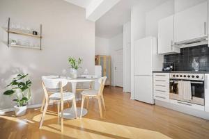 una cocina blanca con mesa y sillas. en Luxurious Retreat in the Middle of City Center en Bergen