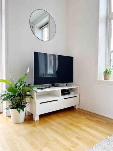 una sala de estar con TV en una cómoda blanca en Luxurious Retreat in the Middle of City Center, en Bergen