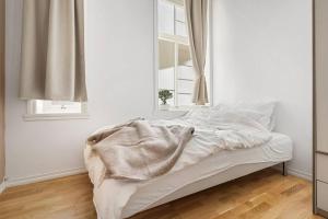 a white bed in a room with a window at Luxurious Retreat in the Middle of City Center in Bergen