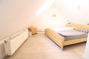 ein kleines Schlafzimmer mit einem Bett und einer Treppe in der Unterkunft Appartmenthaus Nordlicht in Cuxhaven