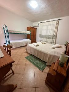a bedroom with two twin beds and a window at Agriturismo Su Barraccu in Loceri