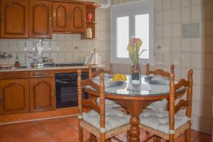 a kitchen with a table with two chairs and a sink at CASA PUERTA ARABE - by Allexperiences in Setenil