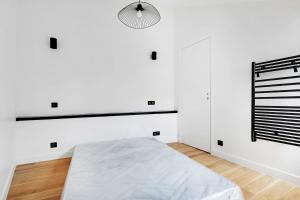 a white room with a bed and a lamp at Cosy renovated 1BDR on rue des Archives Marais Clim 5 in Paris