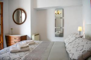 1 dormitorio con cama, espejo y tocador en CASA PUERTA ARABE, en Setenil