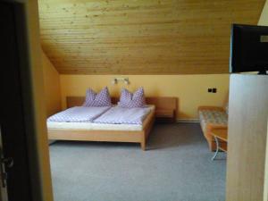a bedroom with a bed with purple pillows on it at Penzion Adam - Makov in Makov