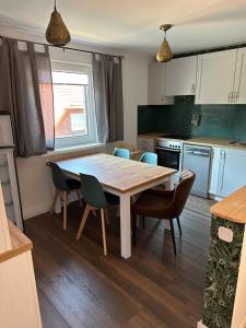 cocina con mesa y sillas en Küstenkind - 3 Schlafzimmer - 5 Personen en Lobbe