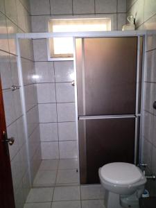 a bathroom with a toilet and a shower with a door at Rancho Rio Dourado, um paraíso! in Promissão