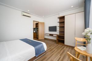 a bedroom with a bed and a desk and a tv at Melody Hotel in Da Nang