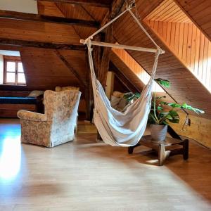 a hammock in a room with a couch and a chair at Apartmán RN in Banská Štiavnica