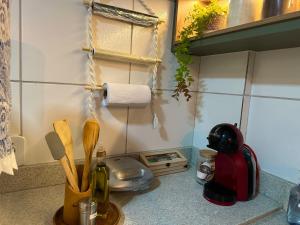 um balcão de cozinha com uma garrafa de vinho e utensílios em Apê Central Bonito em Bonito