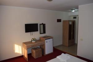 Zimmer mit einem Wand-TV und einem Kühlschrank in der Unterkunft Hotel Ibiza in Eforie Nord