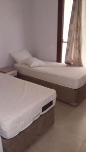 2 camas individuales en una habitación con ventana en Deniz rezidans en Bodrum