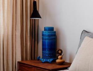 un jarrón azul sentado en una mesa junto a una cama en Prestigious in Prahran, en Melbourne
