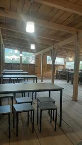 a room with tables and benches in a building at Guesthouse and restaurant SVANURI SAKHLI in Ushguli