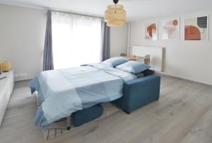 a bedroom with a blue bed with blue pillows at La Villa des Arts in Évry-les-Châteaux