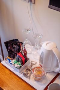 a table with wine glasses and a tea kettle at The Old Coach House in Ripon