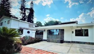 a white house with a driveway in front of it at Hotel 12 Nights in Medellín