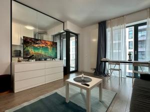 ein Wohnzimmer mit Tisch und Küche in der Unterkunft Boutique Cloud9 Pipera nearby Drpciv in Bukarest