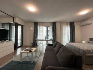 ein Wohnzimmer mit einer Couch und einem Bett in der Unterkunft Boutique Cloud9 Pipera nearby Drpciv in Bukarest