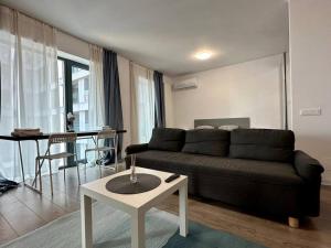 ein Wohnzimmer mit Sofa und Tisch in der Unterkunft Boutique Cloud9 Pipera nearby Drpciv in Bukarest