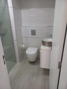 ein weißes Bad mit einem WC und einem Waschbecken in der Unterkunft La Juanita - Residência Marina in Praia