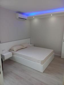 a white bedroom with a bed with a blue ceiling at La Juanita - Residência Marina in Praia