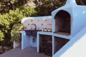uma cozinha exterior com um fogão e um lavatório em Panoramic House em Oliena