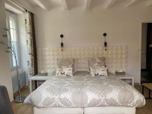 een slaapkamer met een groot bed en 2 tafels bij Saint Palais sur mer Piscine in Breuillet