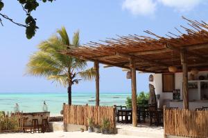 un restaurante en la playa con vistas al océano en Coco Beach Hotel, en Jambiani