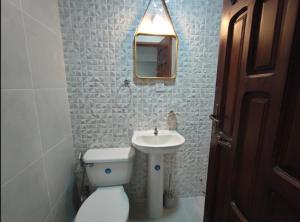 a bathroom with a toilet and a sink and a mirror at Hostal Center in Santa Cruz de la Sierra