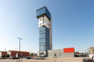 a tall glass building in a parking lot at HTM Venice Suite in Mestre