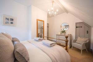 a bedroom with a bed and a dresser and a mirror at High House in Chipping Campden