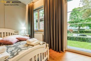 a bedroom with a bed and a large window at Baltic-Apartments - Willa 44 in Świnoujście