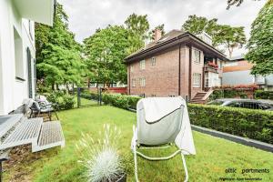 a white chair sitting in the yard of a house at Baltic-Apartments - Willa 44 in Świnoujście