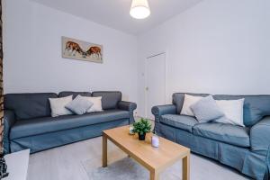 a living room with two blue couches and a coffee table at Homely Spacious Townhouse Near City and Beach - Free Parking in Wallasey