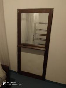 a mirror with a wooden frame on a wall at AB Nest Hiriketiya in Dickwella