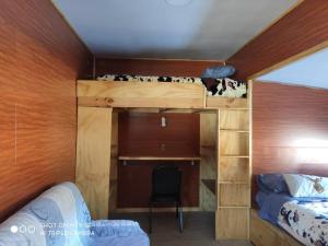 K84 Cabañas في مالالكايلو: غرفة نوم مع سرير بطابقين مع مكتب وكرسي
