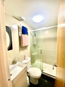 a bathroom with a toilet and a shower and a sink at NewDay Property - Golders Green in London