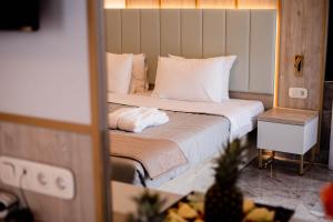 a bedroom with a large bed with a mirror at Tosca Beach Hotel in Paleo Tsifliki