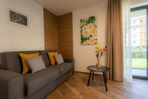 a living room with a couch and a vase of flowers on a table at San Martin Holidays Home - Stay, Work & Fun in Pont-Saint-Martin