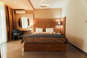 a hotel room with a bed and a mirror at Tosca Beach Hotel in Paleo Tsifliki