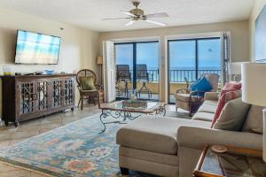 sala de estar con sofá y TV en 504 Surf Dweller by Alicia Hollis Realtor Rentals - Open March 16th Week, en Fort Walton Beach