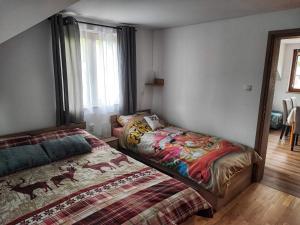 a bedroom with two beds and a window at Apartman 2 RIBIČ in Ogulin