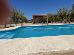 una gran piscina azul con un edificio en el fondo en Villa Valdelobos en Villarrobledo