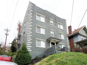 a gray building with white windows on a street at Bright 2BR near downtown in Cincinnati