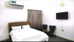 a bedroom with a bed and a flat screen tv at شقة السلمة أم القيوين in Umm Al Quwain