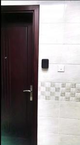 a black door with a box on the wall at شقة السلمة أم القيوين in Umm Al Quwain