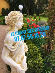 a statue of a cherub in a garden at Le chant des oiseaux - Au pied de la voie cyclable in Crévéchamps