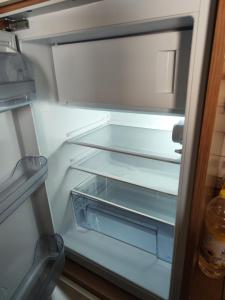 an empty refrigerator with its door open and its empty shelves at Ferienwohnung Lay in Hirschaid