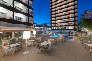 an outdoor patio with tables and chairs and a building at Climia Belroy 4 Sup in Benidorm